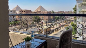 A balcony with a view of pyramids, a street, and buildings. - Hammis Pyramids View  (Giza)