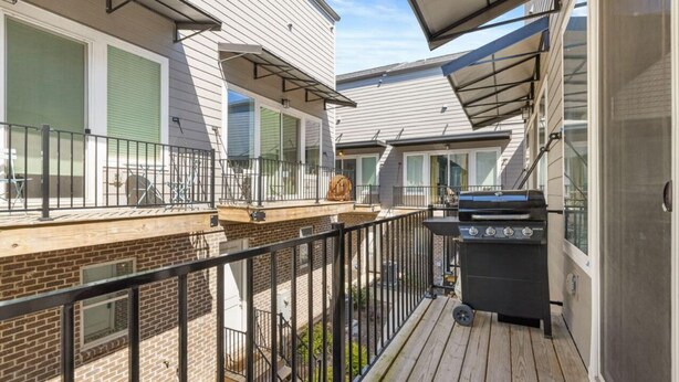 A balcony with a barbecue grill, a wooden deck, and a view of neighboring houses. - Cozy townhome in charming Chattanooga downtown with fastest WiFi, sleep for 5  (Chattanooga)