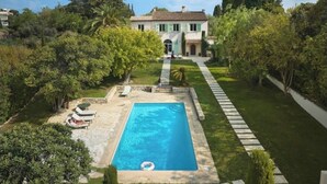 A villa with a swimming pool, surrounded by lush greenery and a well-maintained garden. - Villa El Sol Juan Les Pins (Antibes)