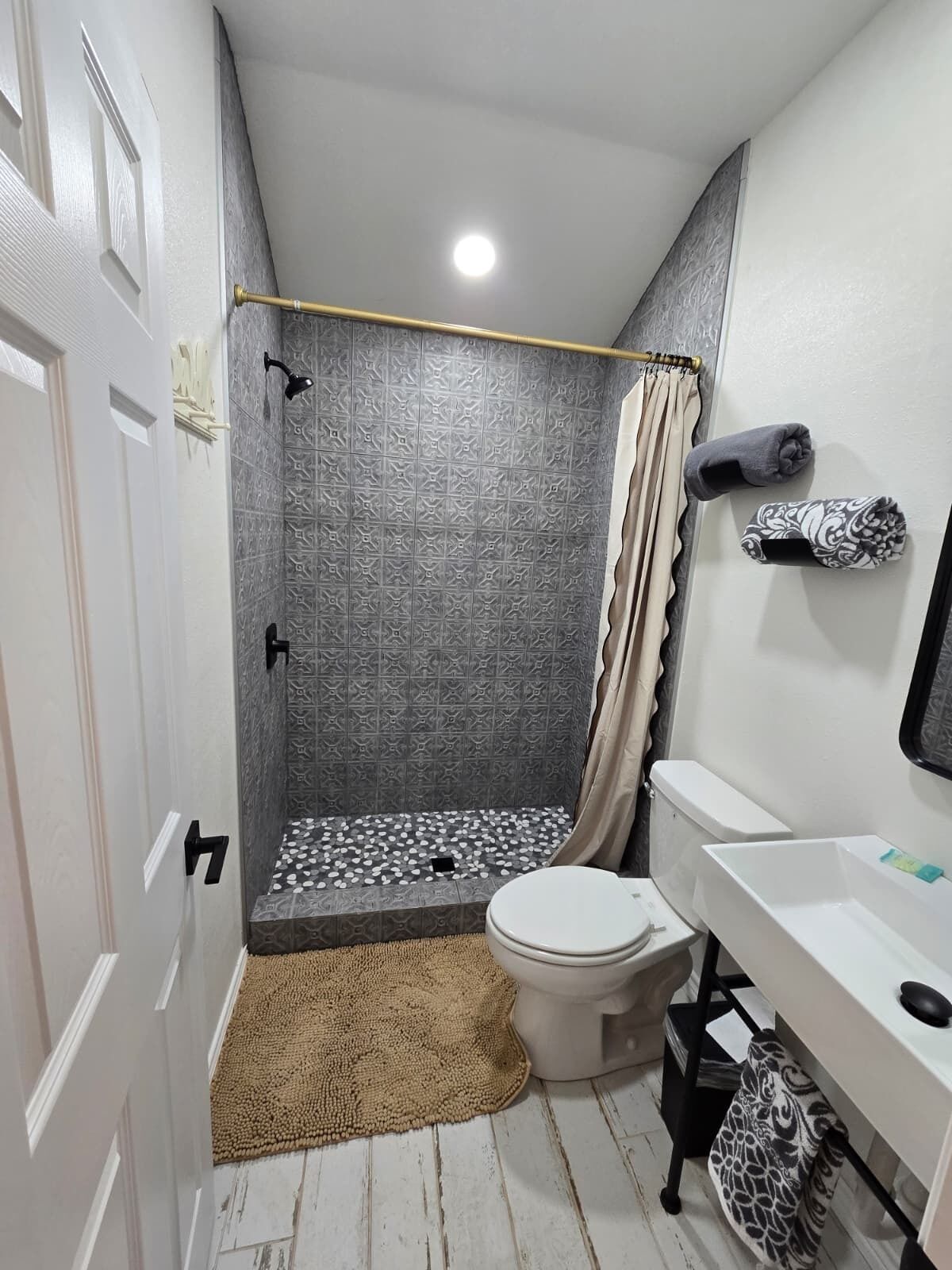 A bathroom with a shower, toilet, and sink.
