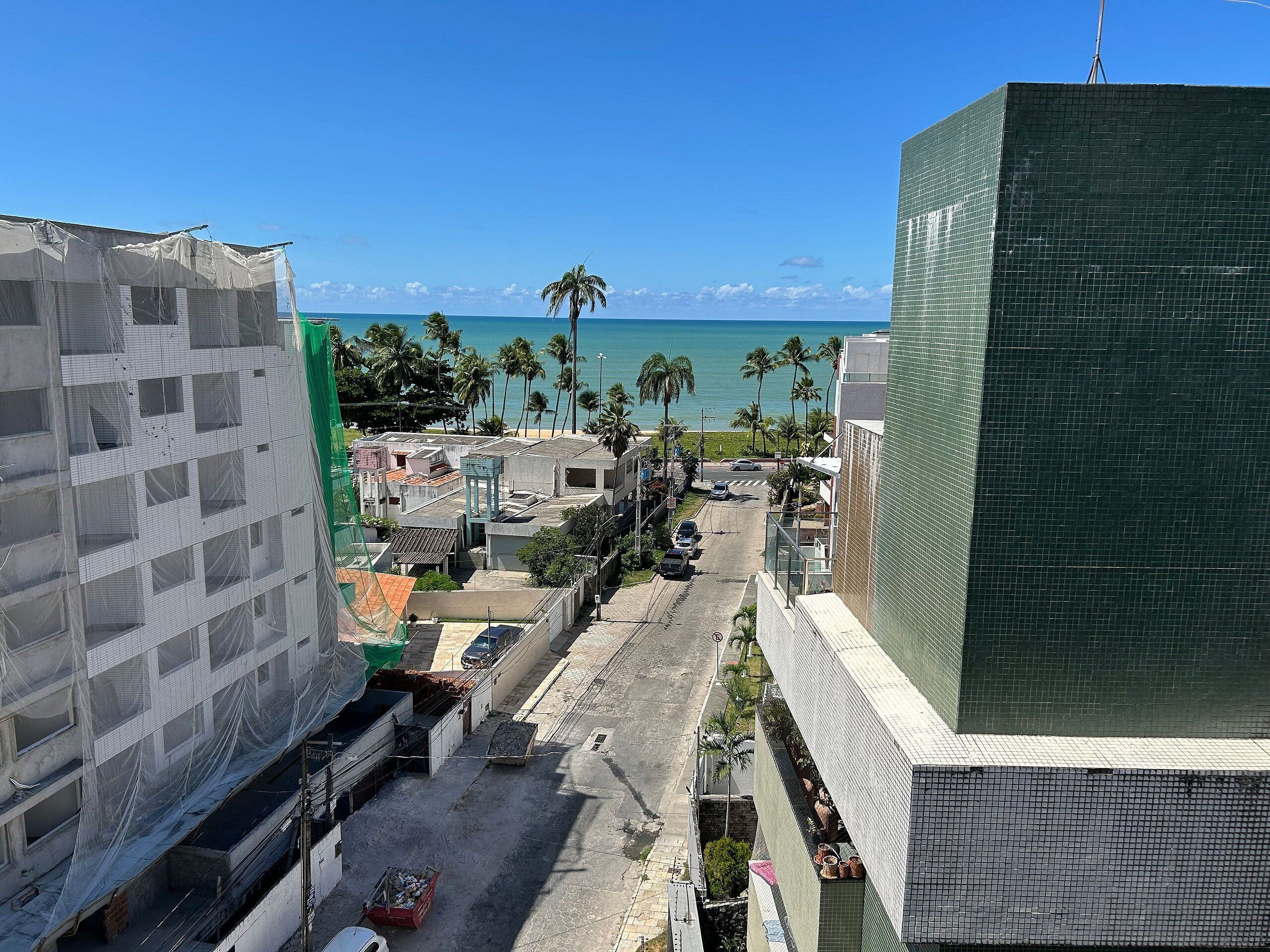 A coastal urban area with buildings, a street, and a view of the ocean.