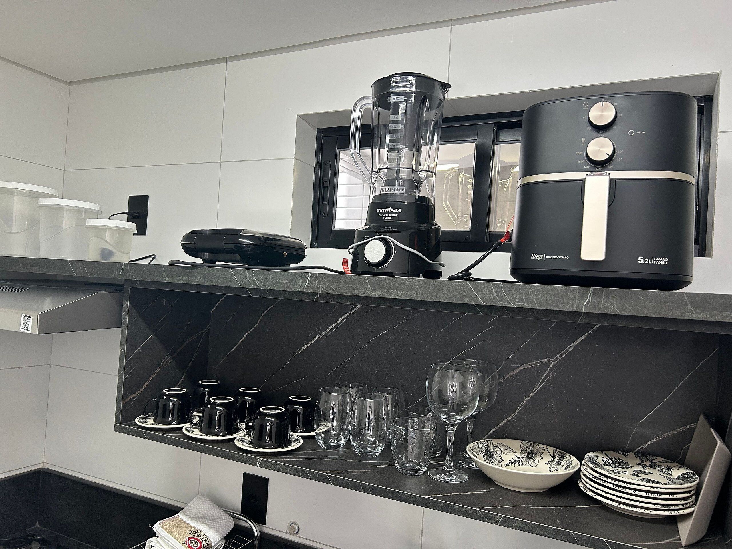 A kitchen with a blender, coffee maker, and a microwave.