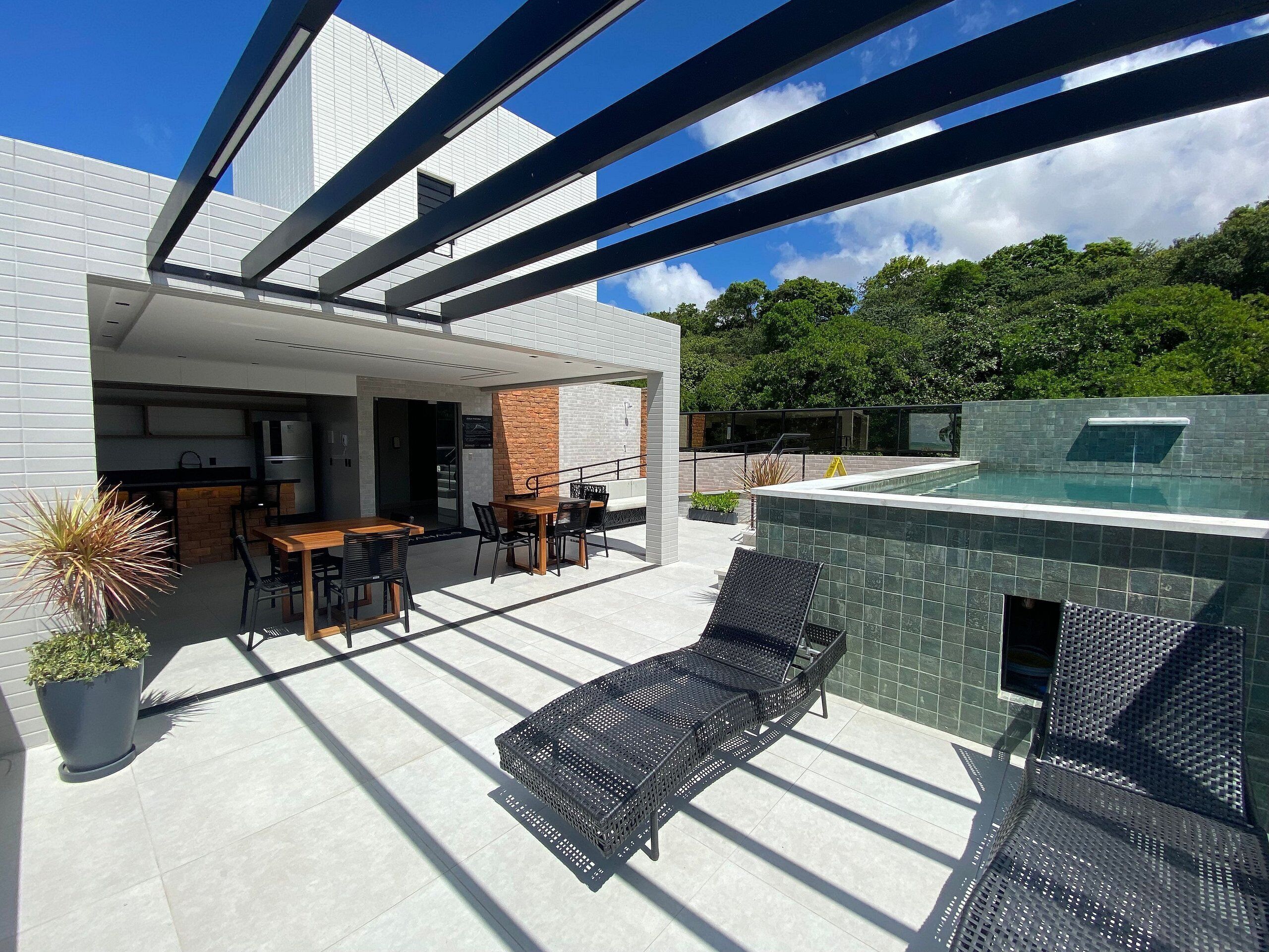 Eine moderne Außenpatio mit Pool, Sitzgelegenheit und Küche.