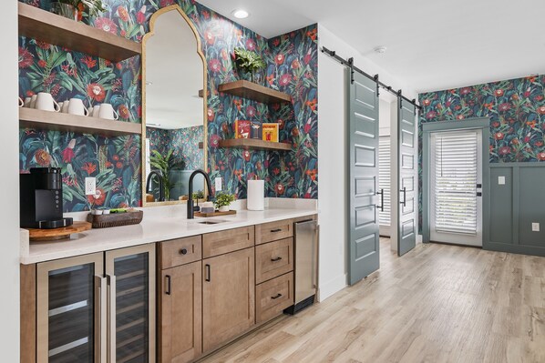 A modern kitchen with wooden cabinets, a white countertop, and a floral backsplash. - Casa Blanca | Rooftop Bar • Elevator • Golf Cart • 400' Beach Access (Miramar Beach)