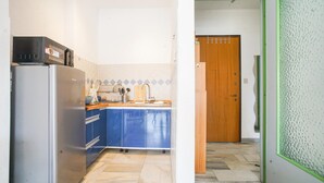 Una cocina compacta con refrigerador, estufa y lavamanos.