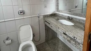 A bathroom with a toilet, sink, and shower.