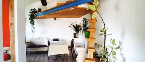 Una habitación con escalera de madera, una mesa de comedor y sillas.