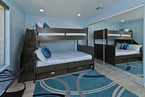 Una camera con letto a castello, uno specchio, una scrivania e una sedia.