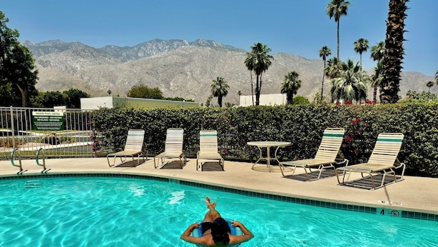 A swimming pool with clear blue water, surrounded by lounge chairs and a sign indicating no smoking, vaping, or dogs allowed. - Mojo Dojo Dog-Friendly 2BR/2BA in Mesquite Country Club by The Prescot Preserve (Palm Springs)