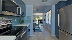 A modern kitchen with stainless steel appliances, a tiled backsplash, and a wooden floor. - Mojo Dojo Dog-Friendly 2BR/2BA in Mesquite Country Club by The Prescot Preserve (Palm Springs)