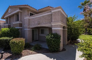 A two-story house with a stone facade, a front porch, and a well-maintained garden.