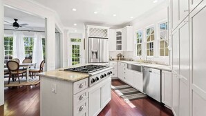 A modern kitchen with white cabinetry, a gas stove, and a dishwasher. - 20 Acre Retreat Near Apex-Rentable Event Venue (New Hill)