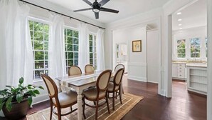 A dining room with a table, chairs, a ceiling fan, and a view of the outdoors. - 20 Acre Retreat Near Apex-Rentable Event Venue (New Hill)