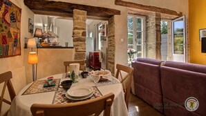 A cozy dining area with a table set for two, a lamp, and a stone pillar. - Chez Isabelle - DINAN (DINAN)