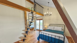 A bedroom with a loft-style bed, a wooden staircase, and a chandelier.