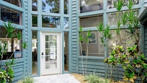 Un bâtiment à la façade bleu clair, avec une porte blanche et de nombreuses fenêtres.