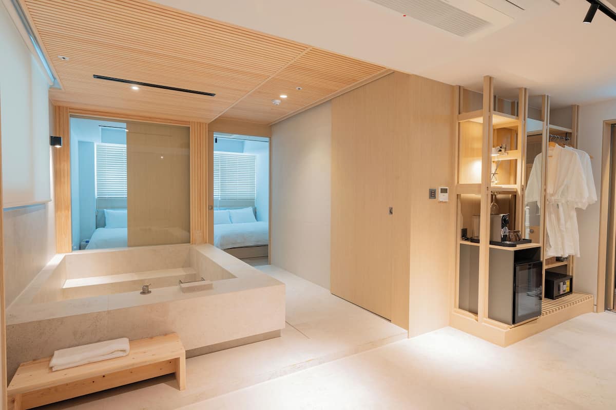 Un baño moderno con una bañera grande, detalles de madera y cabina de ducha.