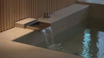 A modern bathroom with a built-in sink and a water feature.