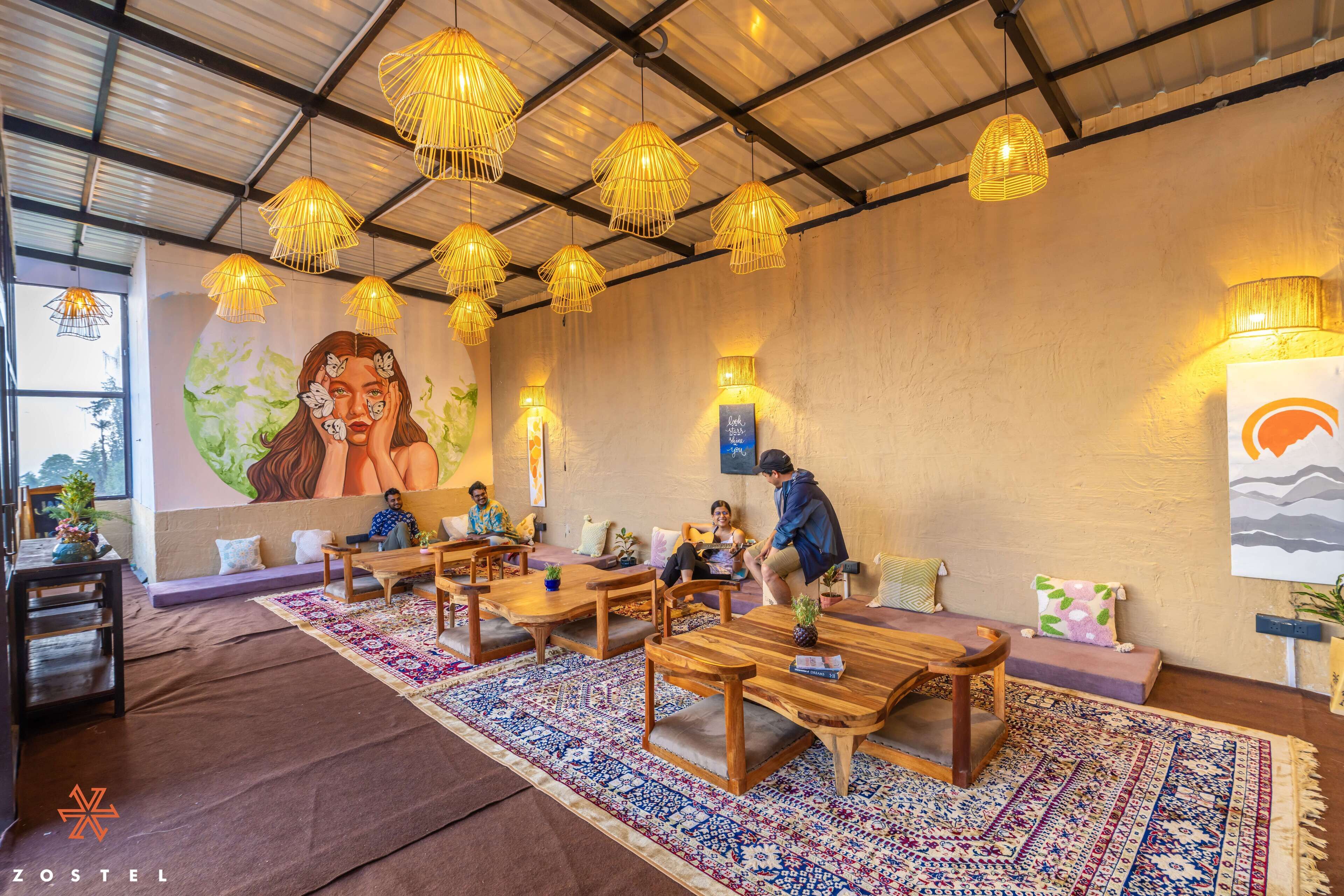 A cozy lounge area with wooden furniture, patterned rugs, and wall art.