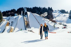 A snowy ski slope with a ski lift and a person walking. - aja Garmisch-partenkirchen (Garmisch-Partenkirchen)