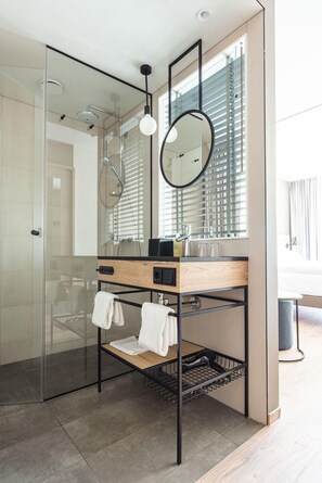 A modern bathroom with a glass shower enclosure, a wooden vanity with a black sink, and a large mirror. - aja Garmisch-partenkirchen (Garmisch-Partenkirchen)