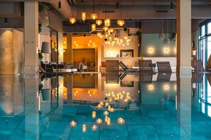 A modern lobby with a reflective floor, seating area, and hanging pendant lights. - aja Garmisch-partenkirchen (Garmisch-Partenkirchen)