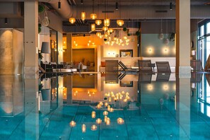 A modern lobby with a reflective floor, seating area, and hanging pendant lights. - aja Garmisch-partenkirchen (Garmisch-Partenkirchen)