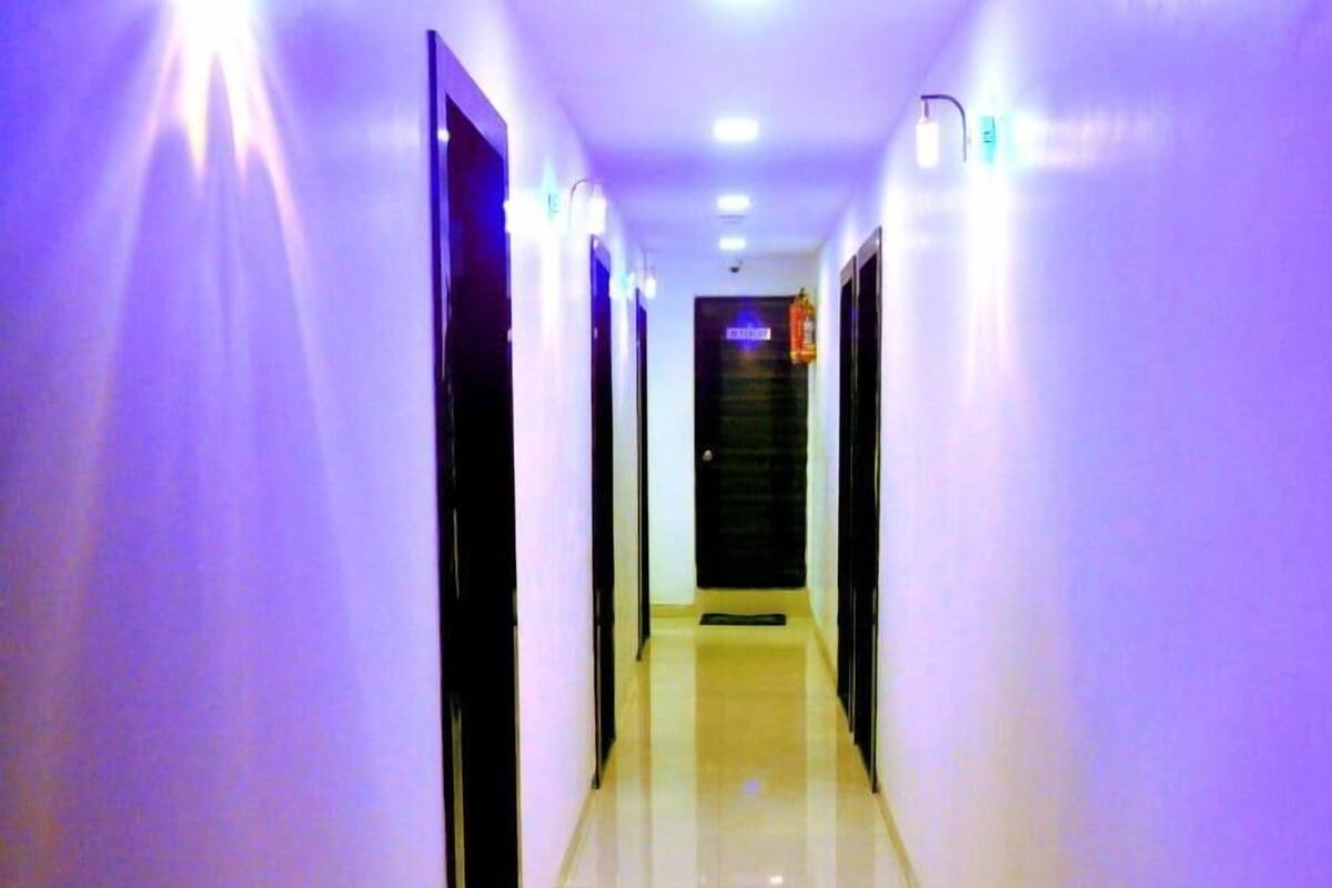 Un long couloir étroit, doté d’un sol réfléchissant et de portes de part et d’autre.