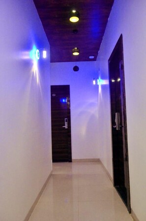 A hallway with a wooden ceiling, recessed lighting, and a door at the end. - The Best Hotel Mumbai (Mumbai)