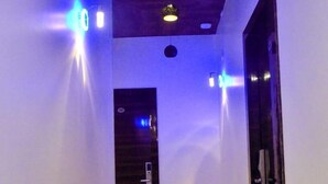 Um corredor com teto de madeira, iluminação embutida e uma porta no final.