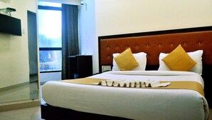 A hotel room with a large bed, a flat-screen TV mounted on the wall, and a window with curtains. - The Best Hotel Mumbai (Mumbai)