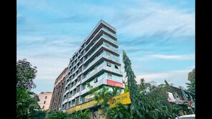 Un immeuble à étages doté d’une architecture moderne, avec une enseigne jaune bien visible indiquant « PMC Bank ».