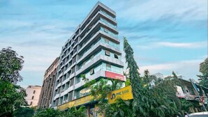 Um edifício de vários andares com design arquitetônico moderno, apresentando uma placa amarela de destaque para o Banco PMC.