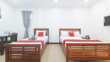 Quarto de hotel com duas camas, uma escrivaninha e uma cadeira.