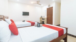 A hotel room with two single beds, a TV mounted on the wall, a wooden door, and a small shelf with items. - Reddoorz @ Rj's Bldg Near Lyceum Gen. Trias Cavite (General Trias)