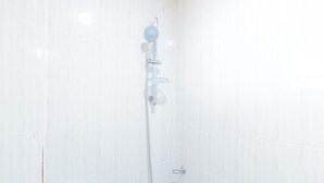 A shower with a handheld showerhead and a wall-mounted control valve. - Reddoorz @ Rj's Bldg Near Lyceum Gen. Trias Cavite (General Trias)