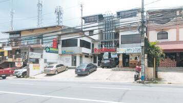 A street view with various commercial buildings, including a pharmacy, a RedDoor store, and a building with a sign for a 15 Cups Cafe.