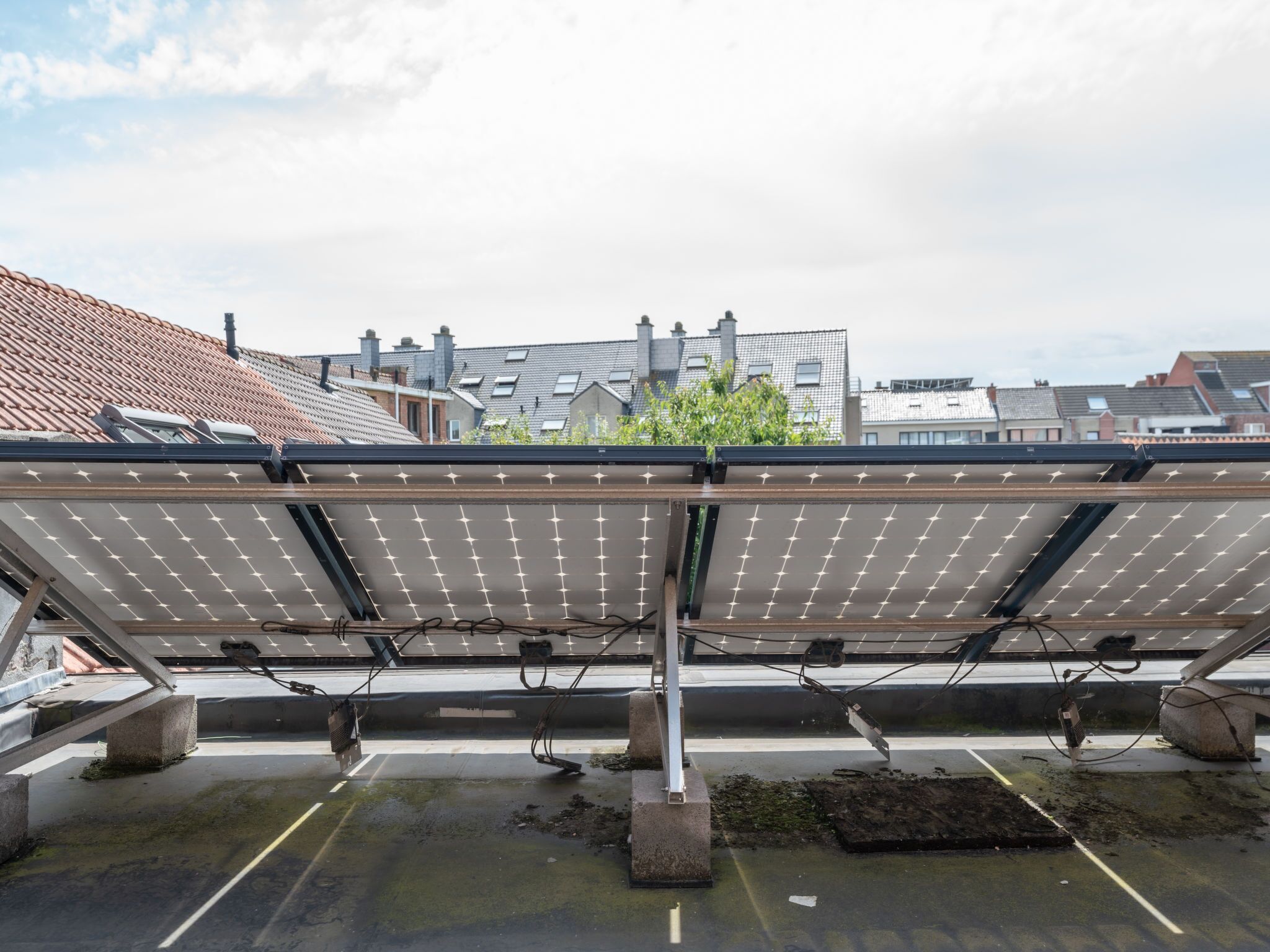 Solar panels on a rooftop with a view of residential buildings in the background.