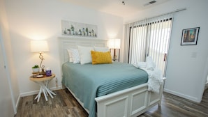 A bedroom with a bed, bedside lamps, a small table with a plant, and a window with curtains. - Tranquil Retreat 4 Miles to Park Entrance Walk to Dining BBQ Balcony (Three Rivers)
