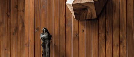 A wooden paneled wall with a geometric sculpture and a modern chair.