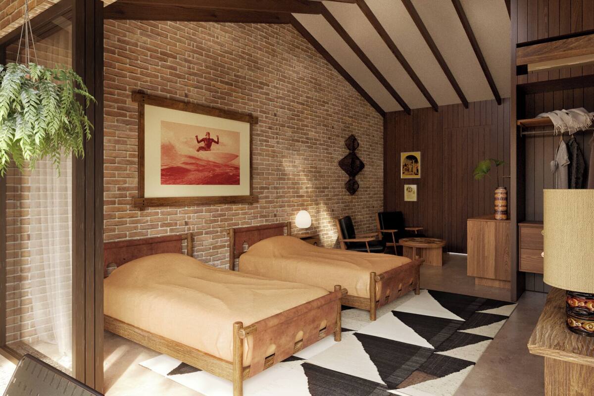 A cozy room with two wooden beds, a brick wall, a hanging plant, and a framed picture.