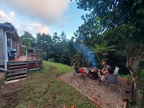 Eine Terrassenanlage im Freien mit Feuerstelle und Sitzgelegenheiten.
