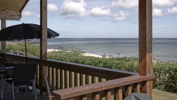 A wooden deck with a view of the ocean and beach.