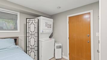 A bedroom with a bed, a wardrobe, a heater, and a door.