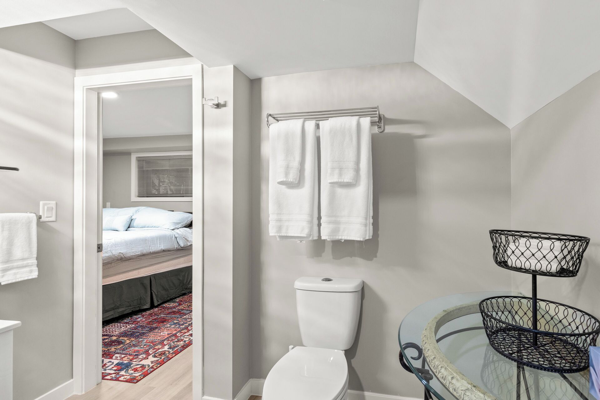 Un baño moderno con inodoro, lavabo de cristal y zona de ducha.