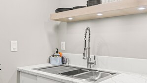 A modern kitchen with a double sink, stainless steel faucet, and a marble countertop.