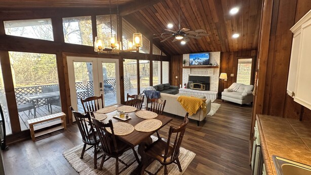 A spacious living area with a fireplace, a dining table with chairs, and a cozy seating area.