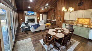 A cozy cabin interior with a dining area, kitchen, and living space.