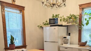 A kitchen with a central island, a refrigerator, a microwave, and a coffee maker. There are chairs and a table with a sign indicating available food and drink options. - Delightful Cabin near a wildlife refuge, 6 miles to Carbondale Illinois. (Carbondale)