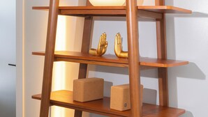 Una estantería de madera con varios niveles, algunos con adornos.